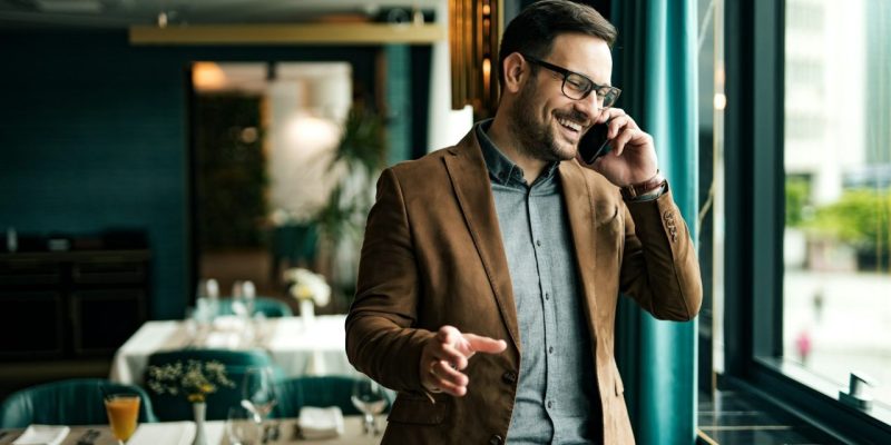 portrait-of-a-smiling-businessman-in-restaurant-talking-on-smart-phone-.jpg